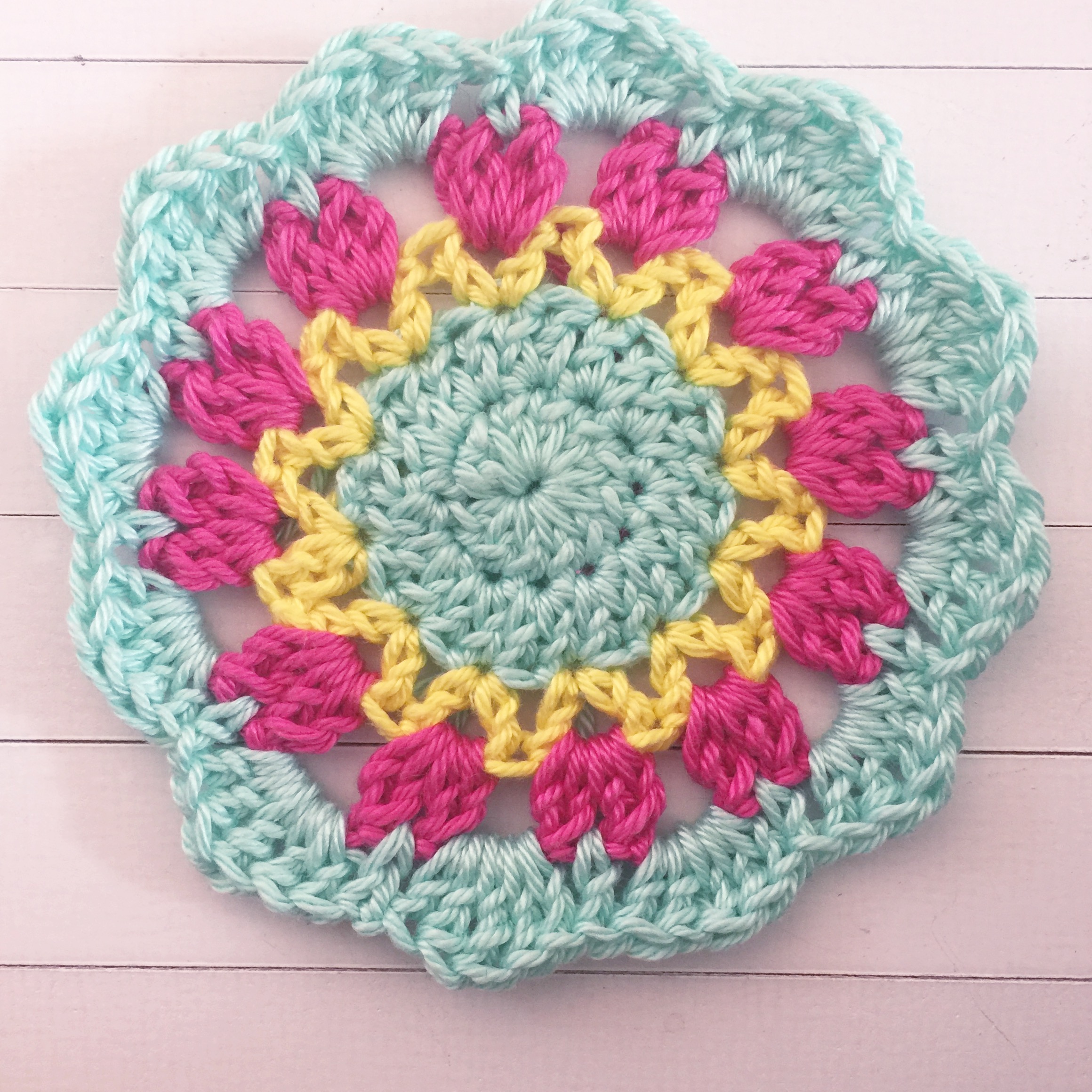 Join next colour to the middle loop of the cluster with a HDC (half double crochet). in the ch space, work a DC, Htr (half treble - YO twice, insert hook, pull up a loop, pull through two loops, YO, pull through all loops), a Tr (treble crochet), Htr and a DC. HDC into the top loop of the next cluster. Repeat this around in each ch space, slip stitch to join.